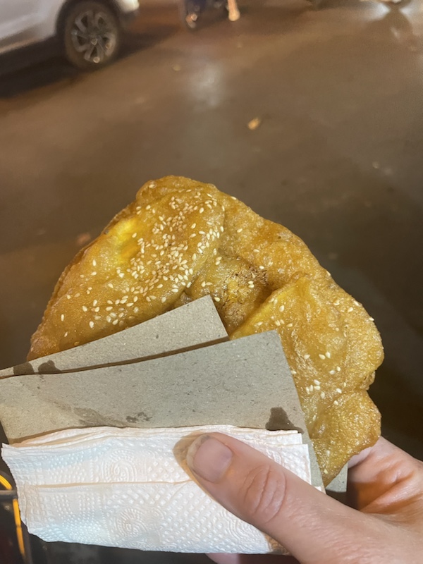 The street vendor frying fruit fritters in Hanoi, Vietnam 